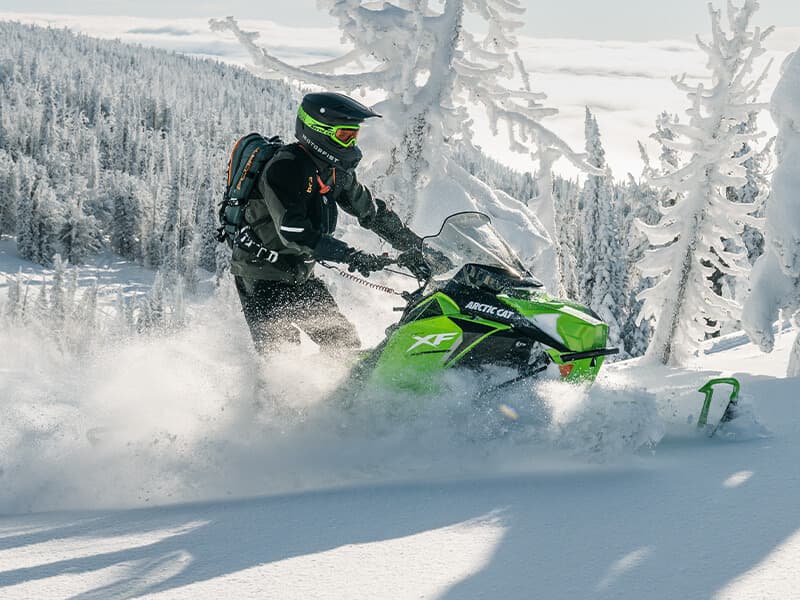 Arctic Cat snowmobile riding through fresh snow